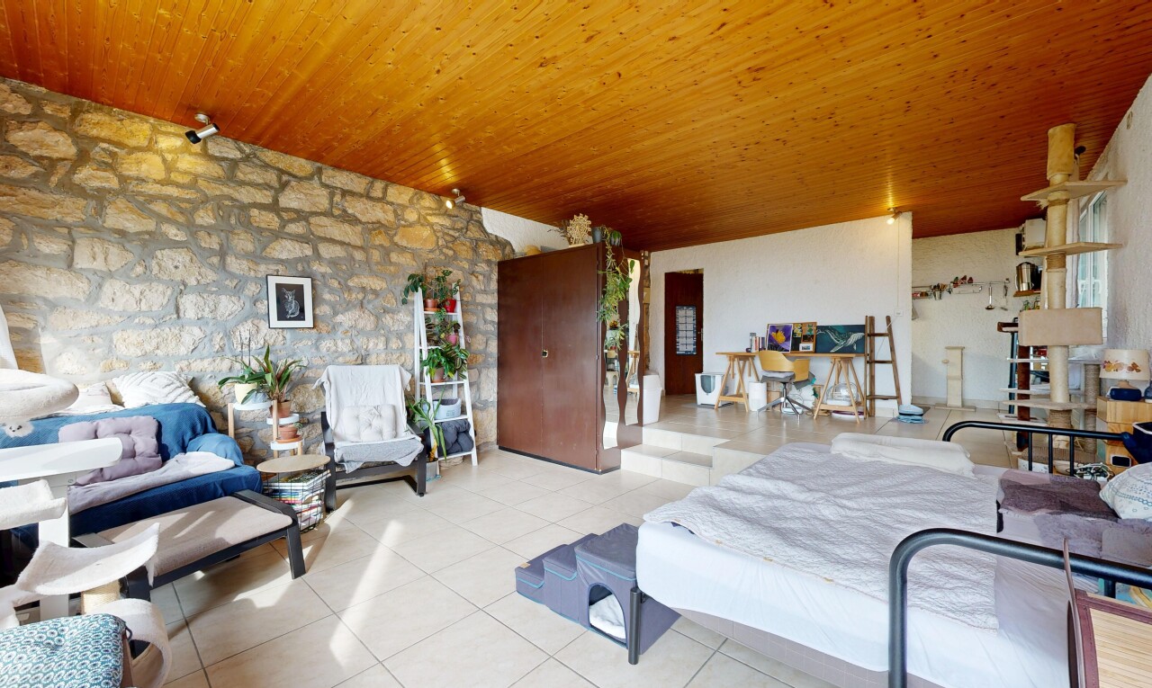 salon avec inside property, mur en pierre, stone wall, sol en carrelage, et tile floor