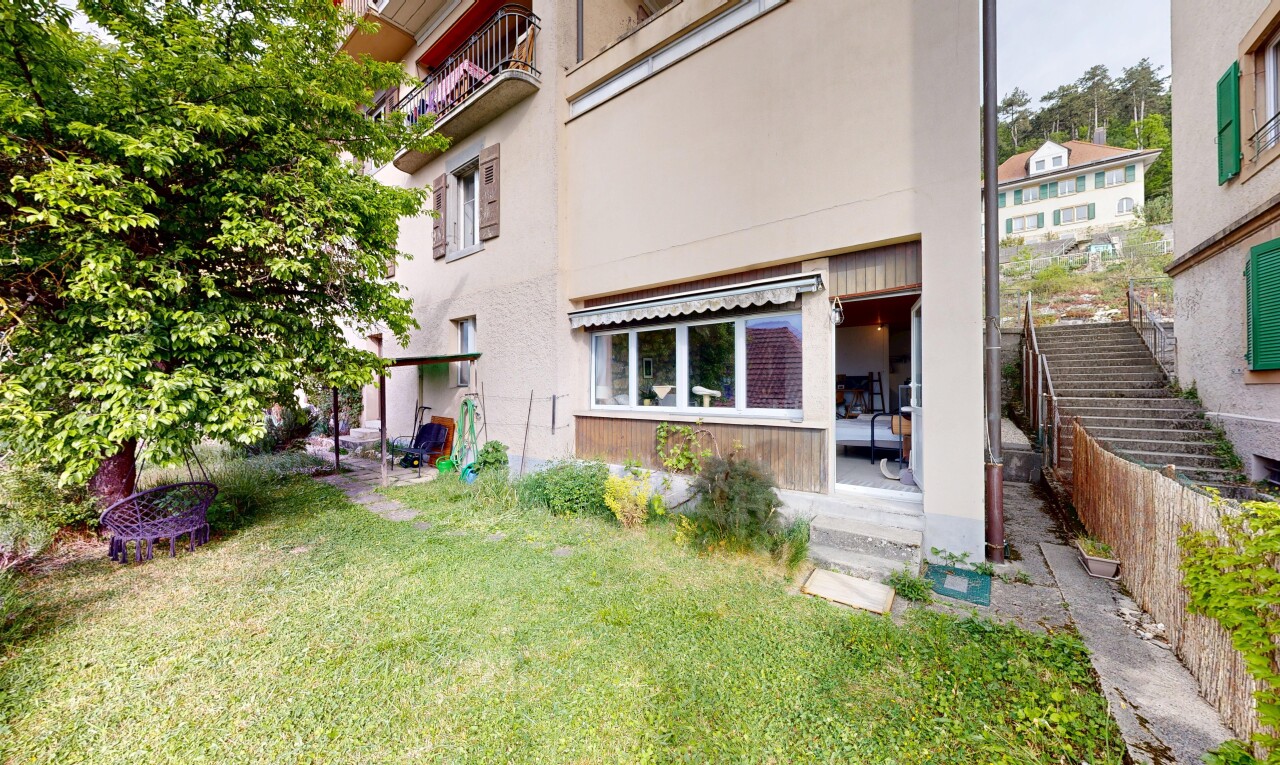 façade avec auvent, bardage en stuc, pelouse, et terrasse