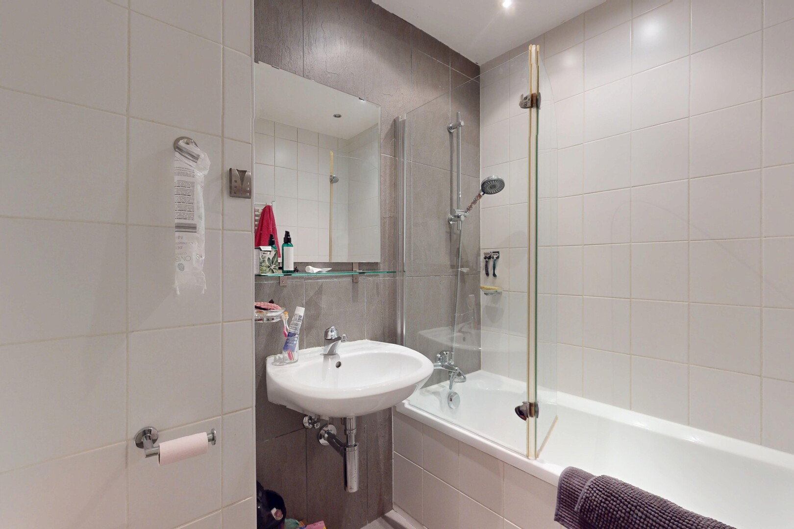 full bath with tiled shower / bath combo and tile walls