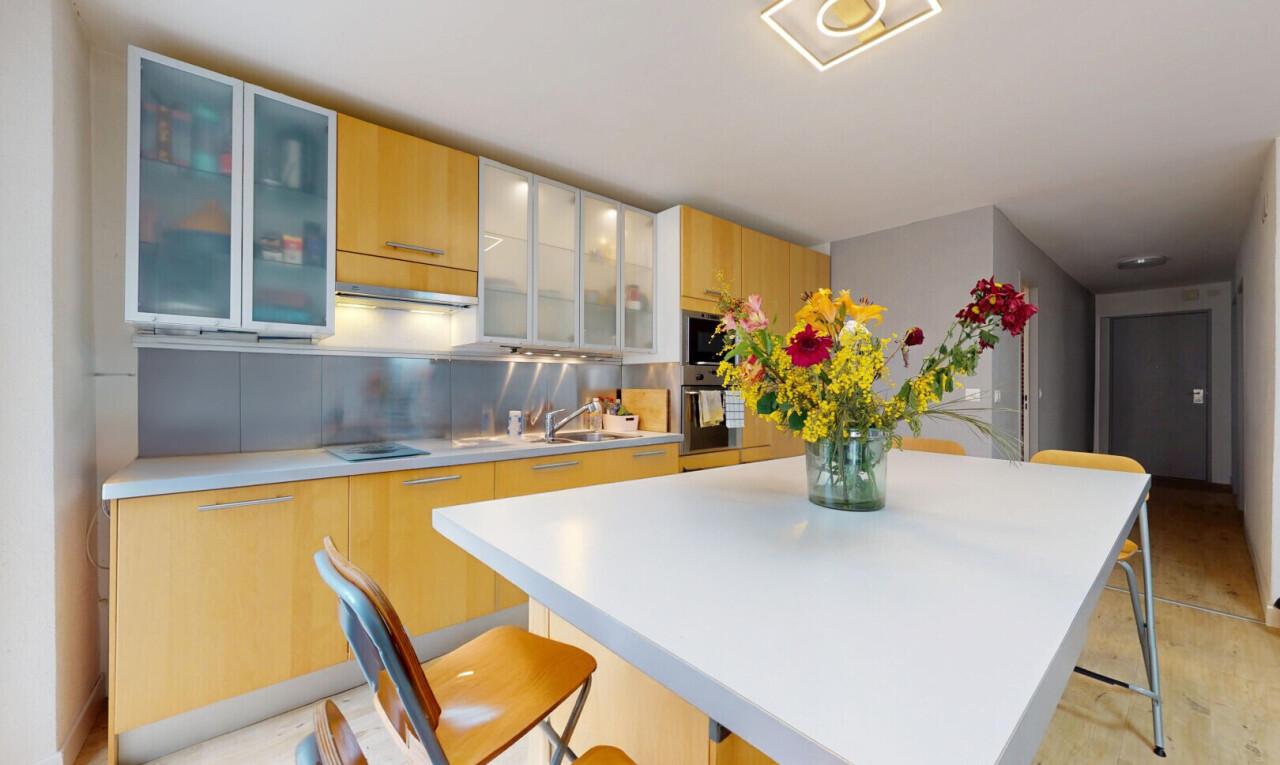 kitchen featuring a kitchen island, light countertops, a kitchen bar, glass insert cabinets, and modern cabinets