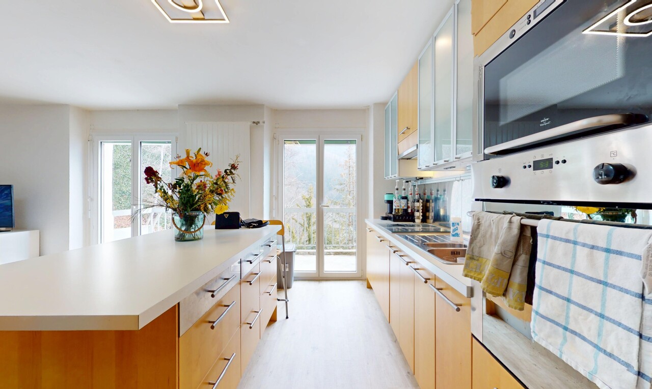 kitchen featuring white oven, stainless steel microwave, a kitchen island, and light countertops