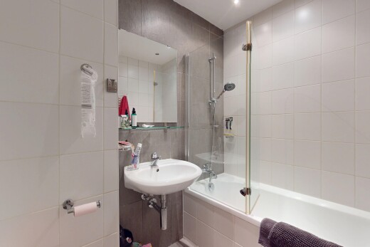 salle de bains avec tile shower, douche-bain combinés, tile wall, mur en carrelage, et miroir