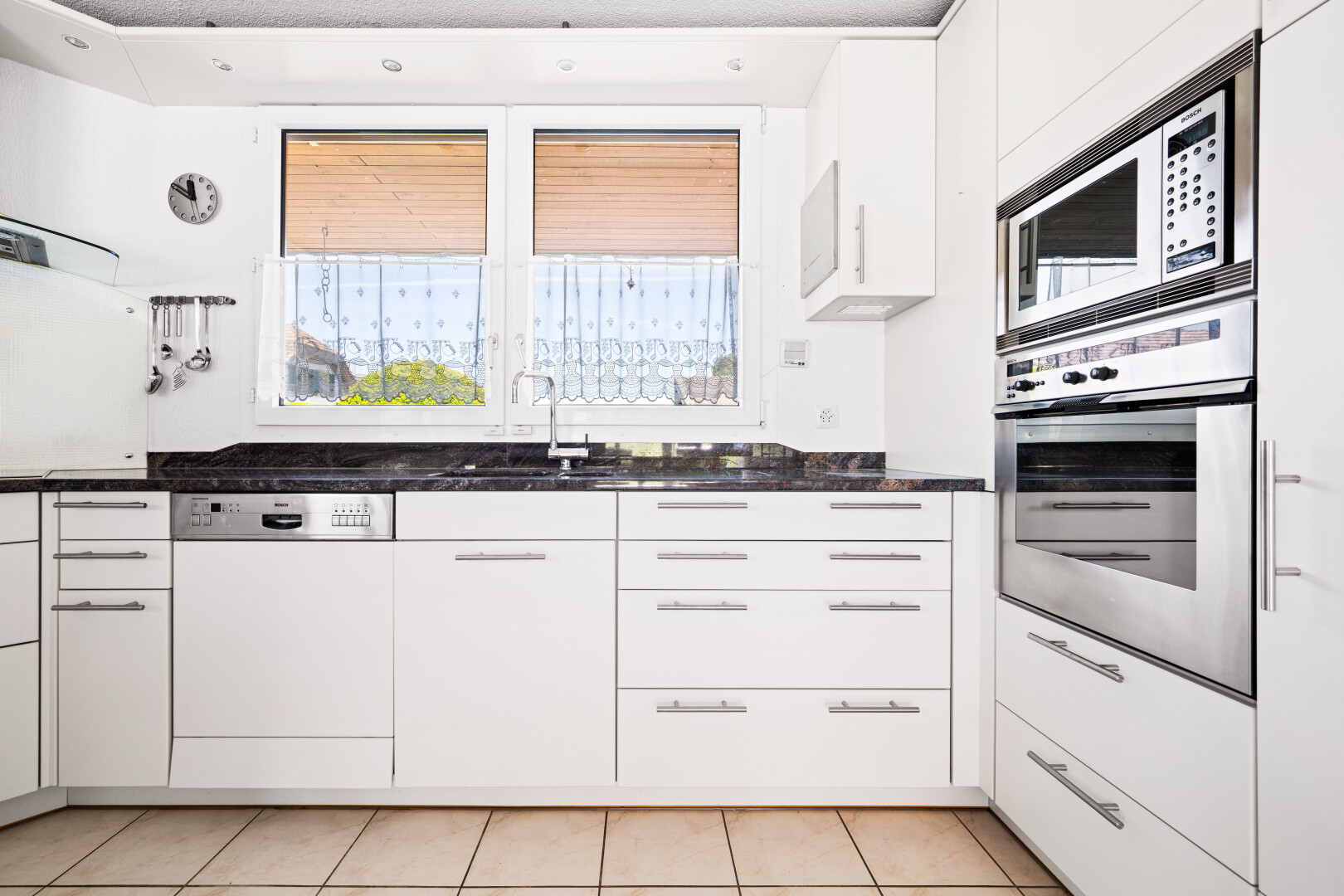 küche mit ofen, white cabinets, weiße schränke, dark countertops, und light floor