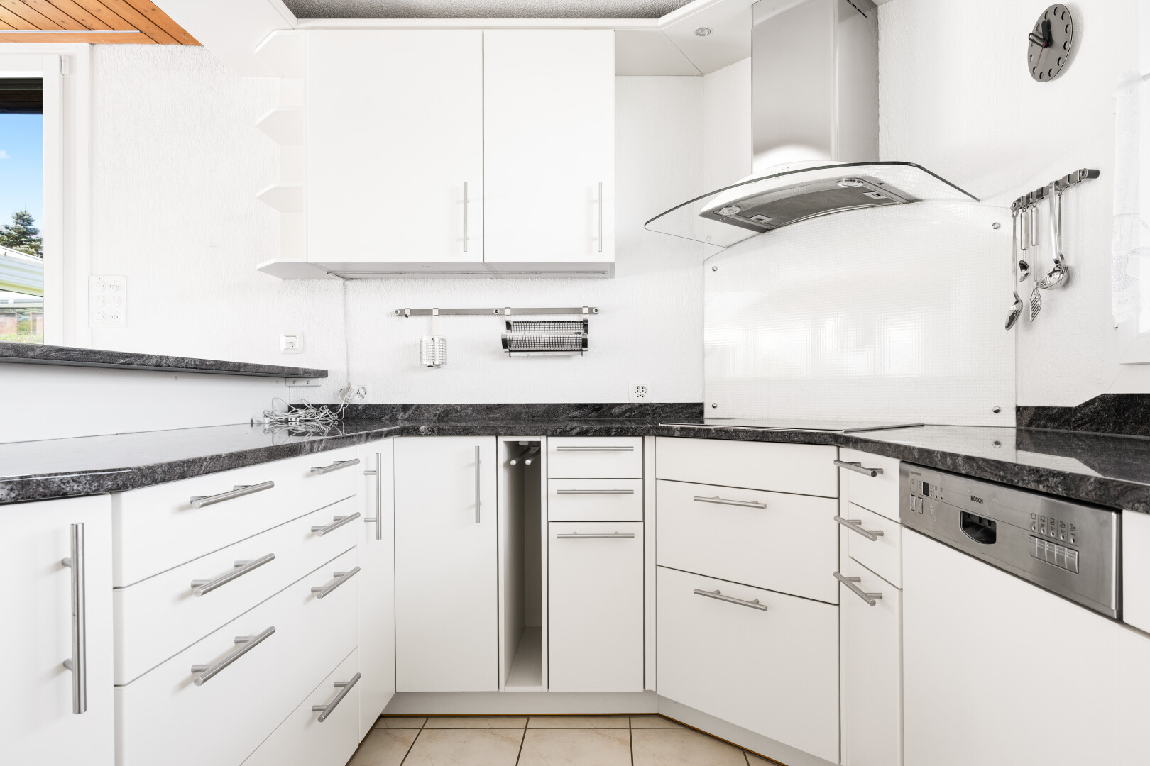 küche mit dark countertops, two heights countertops, dunstabzugshaube, weiße schränke, und white cabinets