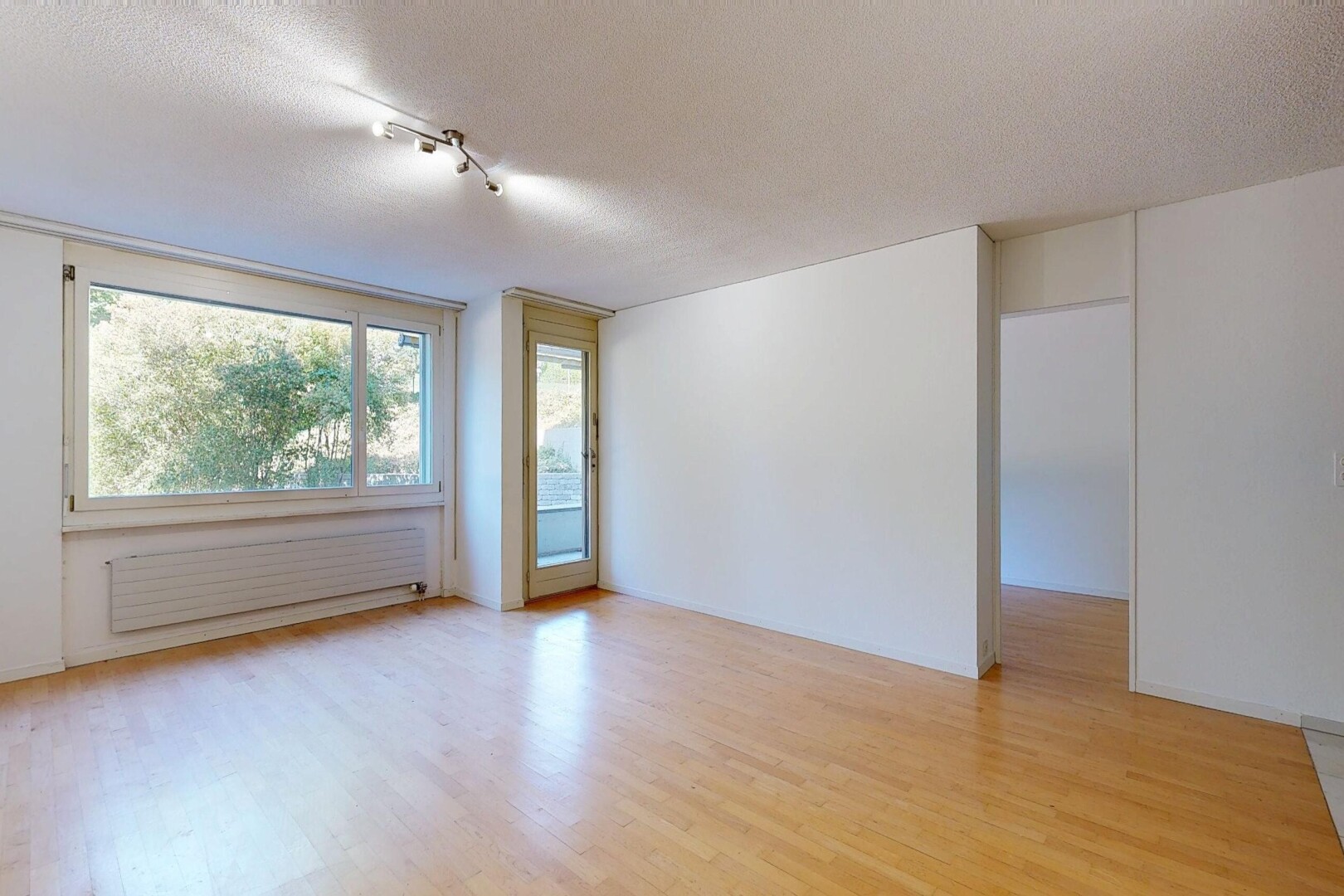 leerer raum mit kühler, inside property, holzfußboden, wood finish floor, und natürliches licht
