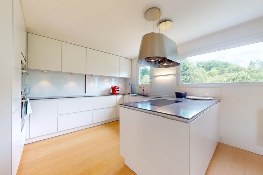 küche mit küchentheke, weiße schränke, holzfußboden, wood finish floor, und natürliches licht