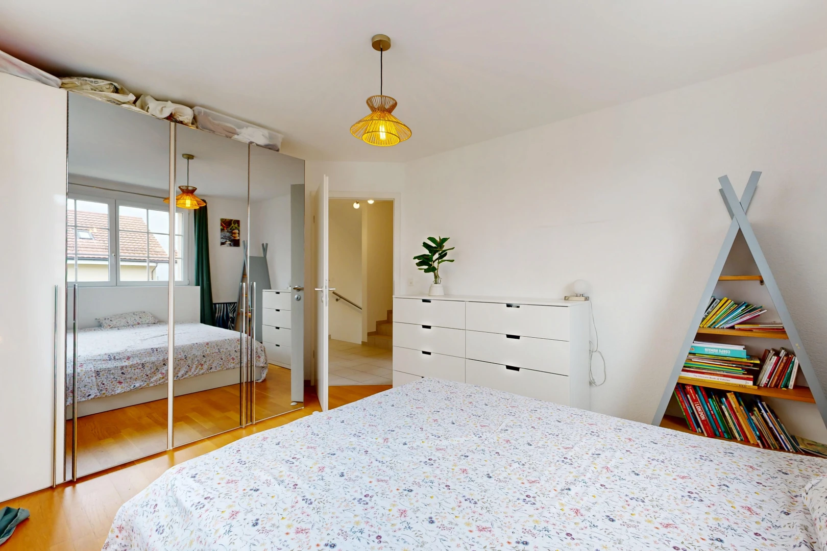 chambre avec éclairage suspendu, wood finish floor, sol en finition bois, placard, et drywall