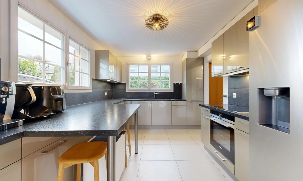 cuisine avec réfrigérateur, plans de travail, dark countertops, lumière naturelle, et light floor
