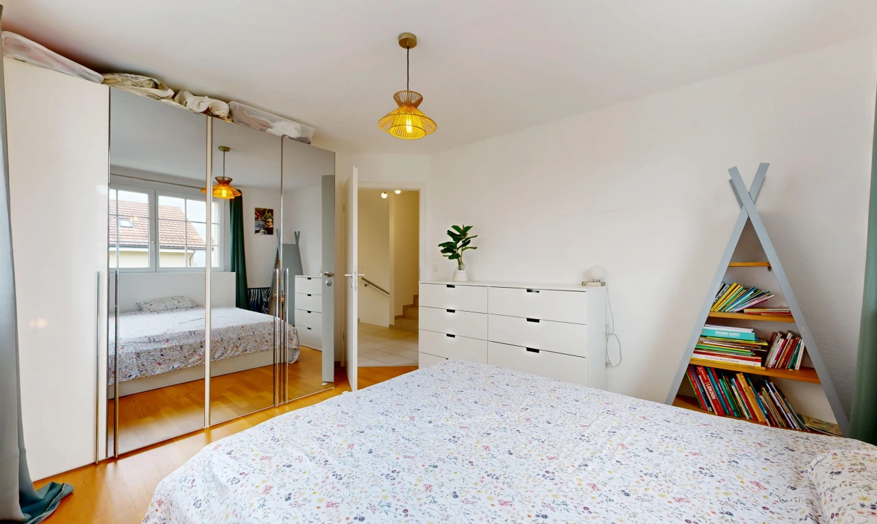 chambre avec éclairage suspendu, wood finish floor, sol en finition bois, placard, et drywall