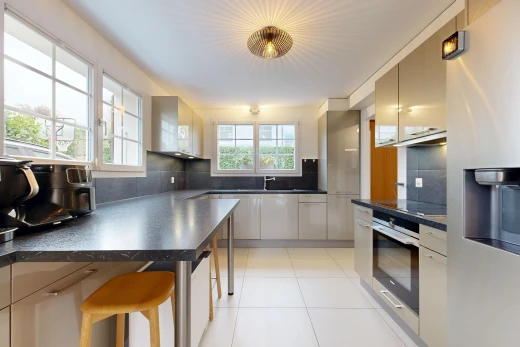 cuisine avec réfrigérateur, plans de travail, dark countertops, lumière naturelle, et light floor