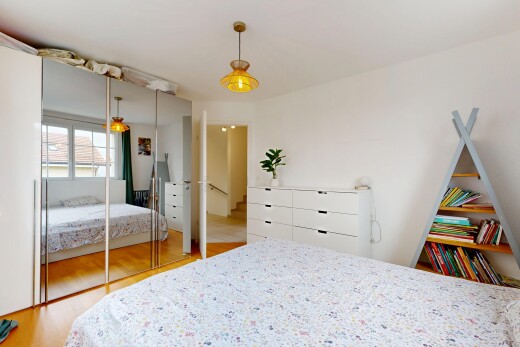 zimmer / schlafzimmer mit pendelleuchte, wood finish floor, holzfußboden, kleiderschrank, und drywall