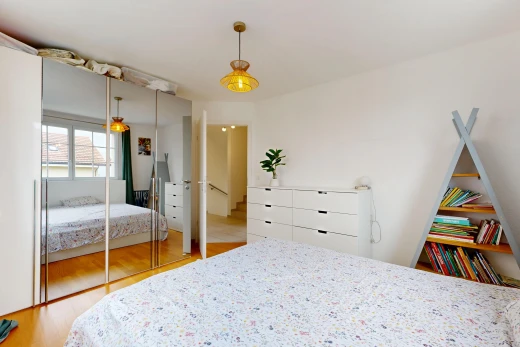 chambre avec éclairage suspendu, wood finish floor, sol en finition bois, placard, et drywall