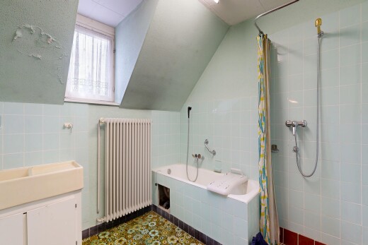 salle de bains avec radiateur, mur en carrelage, tile wall, lavabo (ou coiffeuse selon le contexte), et inside property