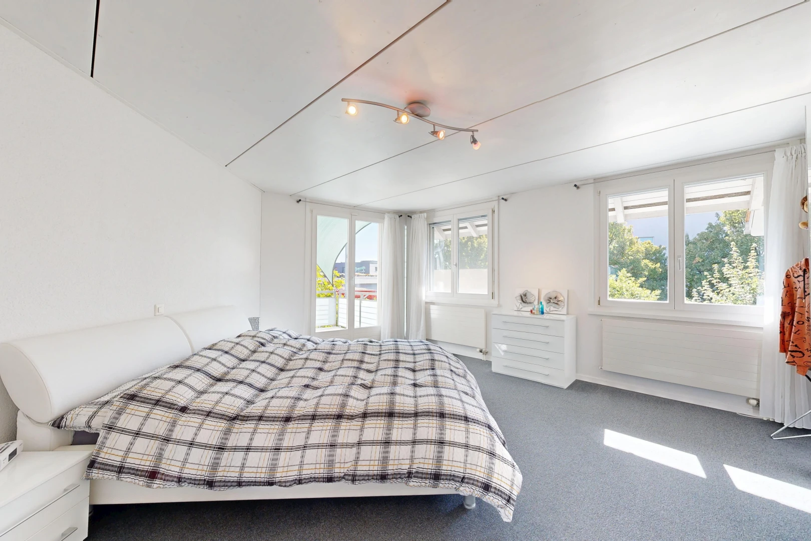 chambre avec éclairage sur rail, carpet, moquette, drywall, et cloison sèche