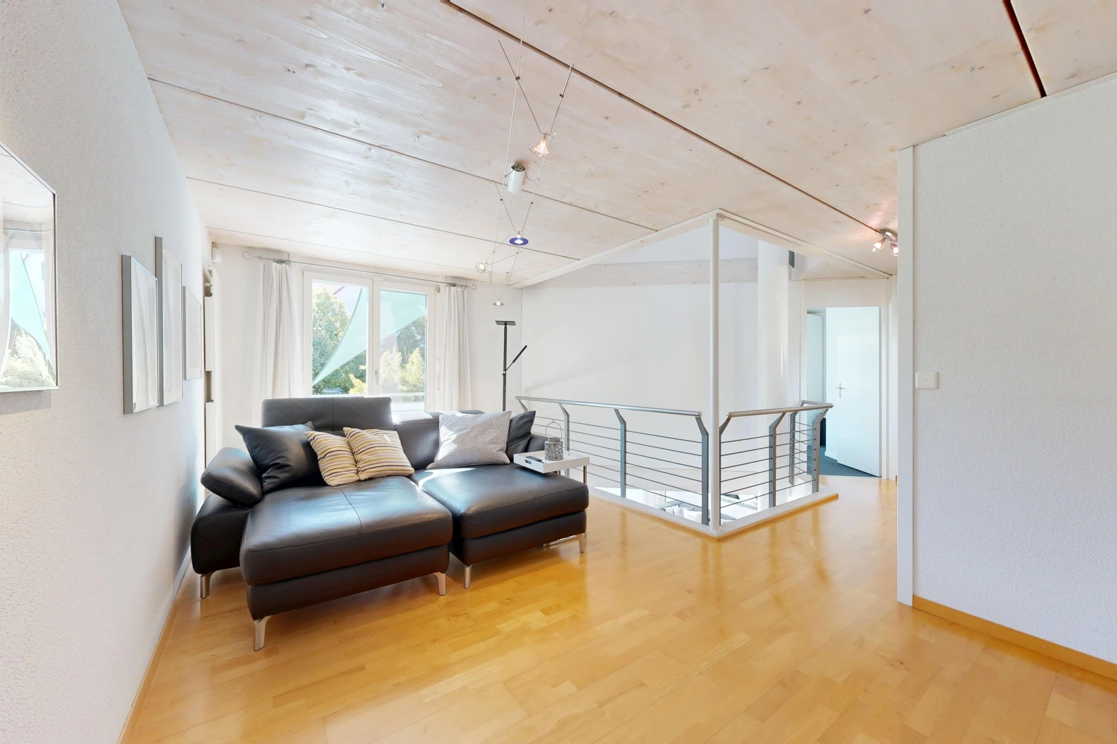 salon avec wood finish floor, sol en finition bois, light floor, inside property, et baseboards wall
