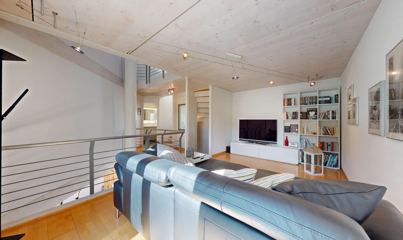 salon avec télévision, étagères intégrées, drywall, cloison sèche, et wood finish floor