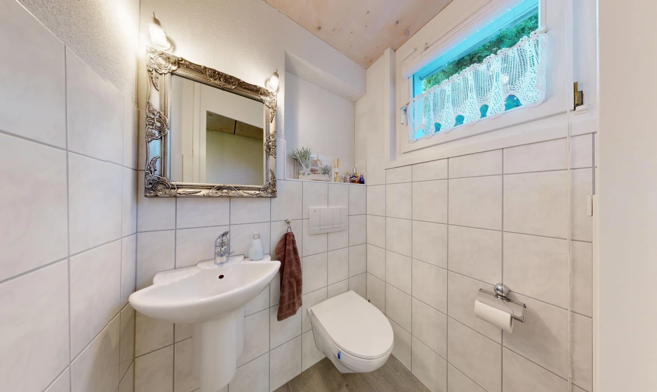 salle de bains avec miroir, tile wall, mur en carrelage, toilette, et inside property