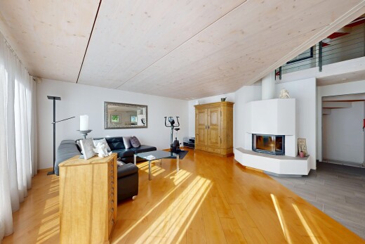 salon avec wood finish floor, sol en finition bois, cheminée, drywall, et cloison sèche