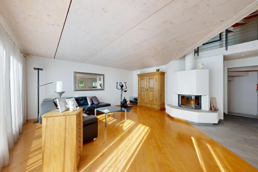 salon avec wood finish floor, sol en finition bois, cheminée, drywall, et cloison sèche