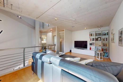 salon avec télévision, étagères intégrées, drywall, cloison sèche, et wood finish floor