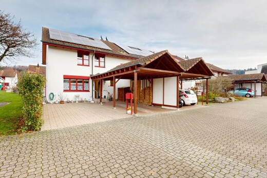 façade avec panneaux solaires, bardage en stuc, property visible, et abri de voiture attaché