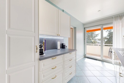 cuisine avec light floor, armoires blanches, white cabinets, plans de travail, et dark countertops