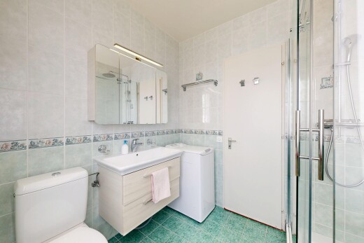 salle de bains avec mur en carrelage, tile wall, lavabo (ou coiffeuse selon le contexte), miroir, et salle de bain complète