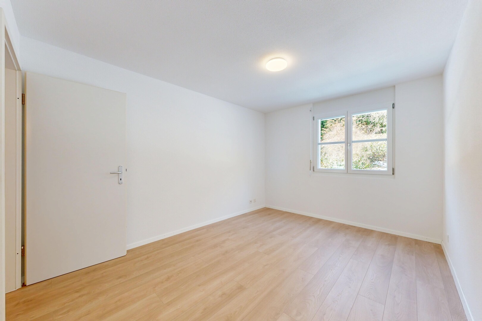 pièce vide avec sol en finition bois, wood finish floor, cloison sèche, drywall, et lumière naturelle
