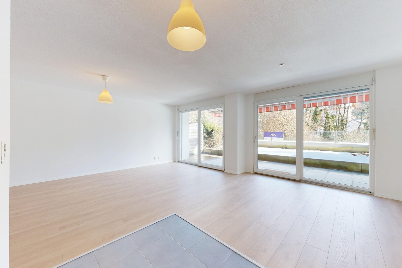 pièce vide avec sol en finition bois, wood finish floor, cloison sèche, drywall, et lumière naturelle