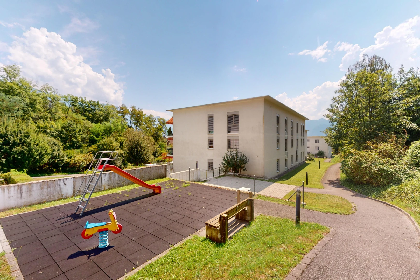 façade avec pelouse, clôture, et terrain de jeux