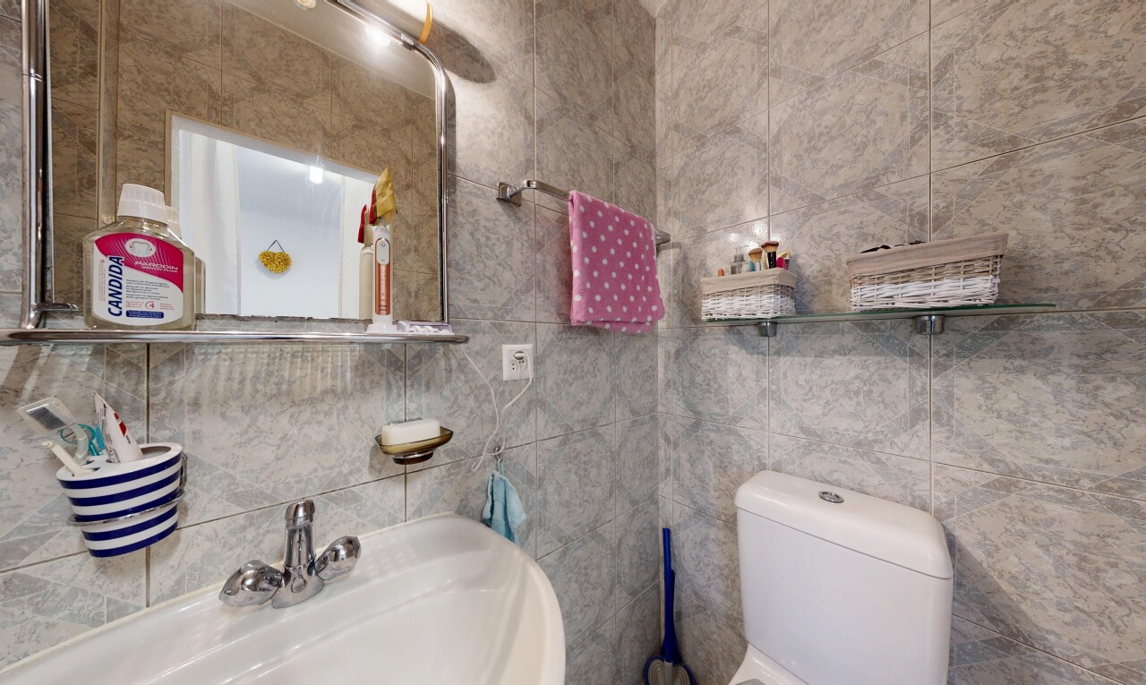 salle de bains avec miroir, évier, tile wall, mur en carrelage, et toilette