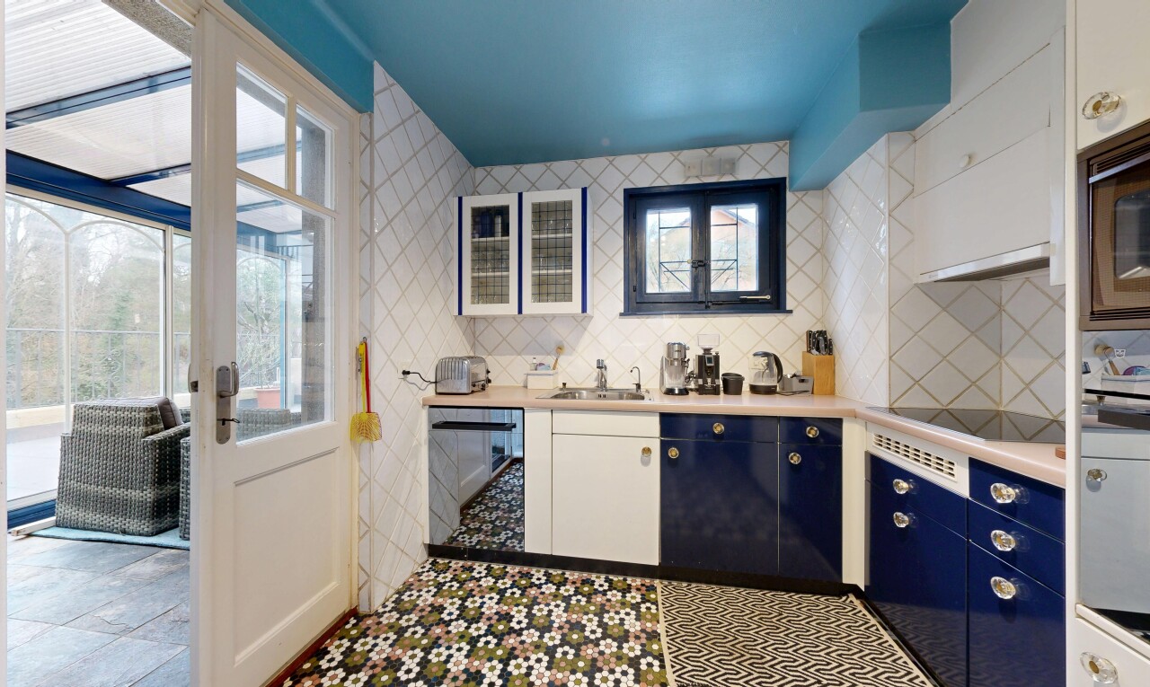 cuisine avec light countertops, plans de travail, natural light, lumière naturelle, et tile wall