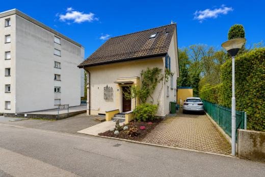 façade avec perron, bardage en stuc, day time, property visible, et aire de stationnement