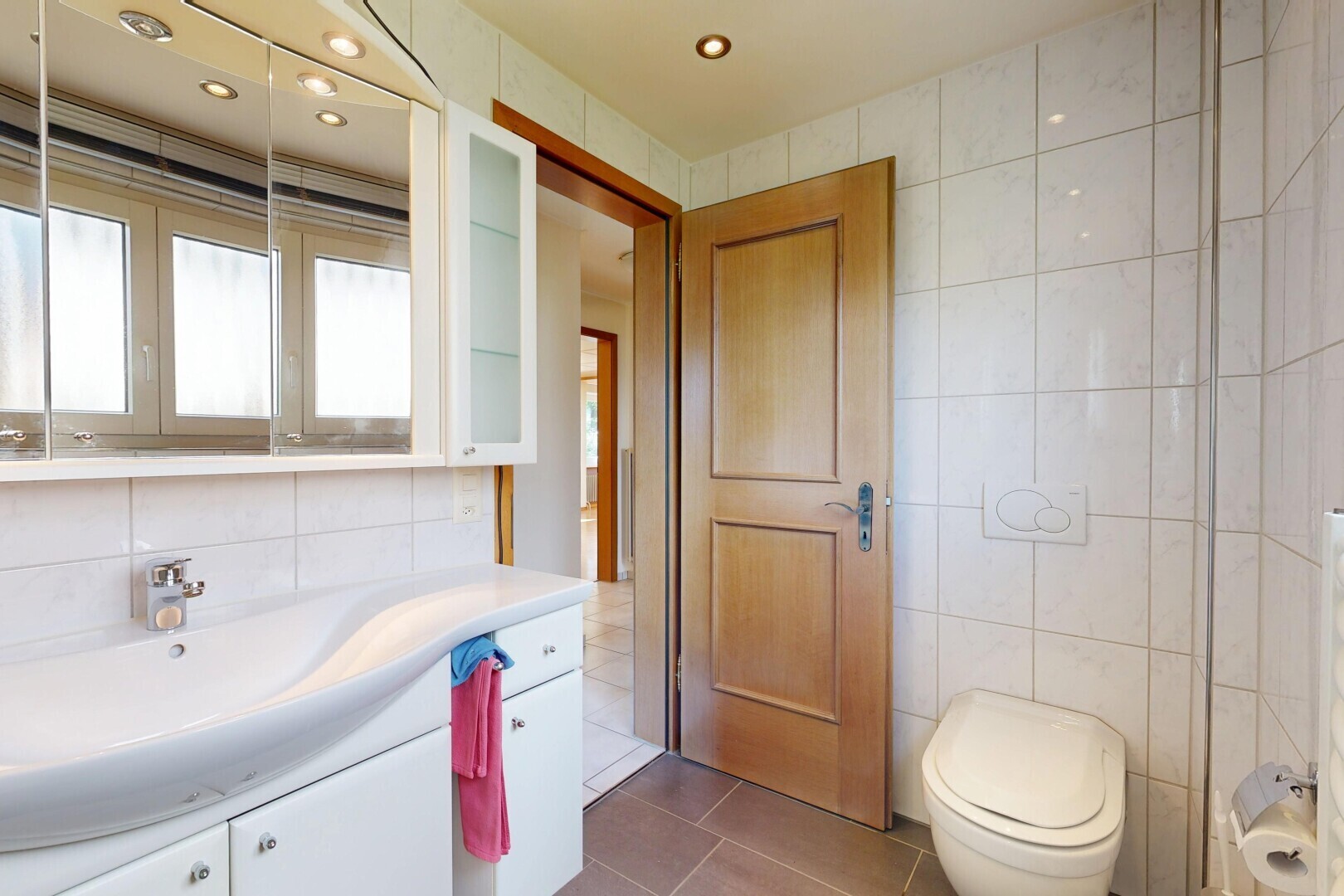 half bath with tile walls, vanity, dark tile patterned flooring, and recessed lighting