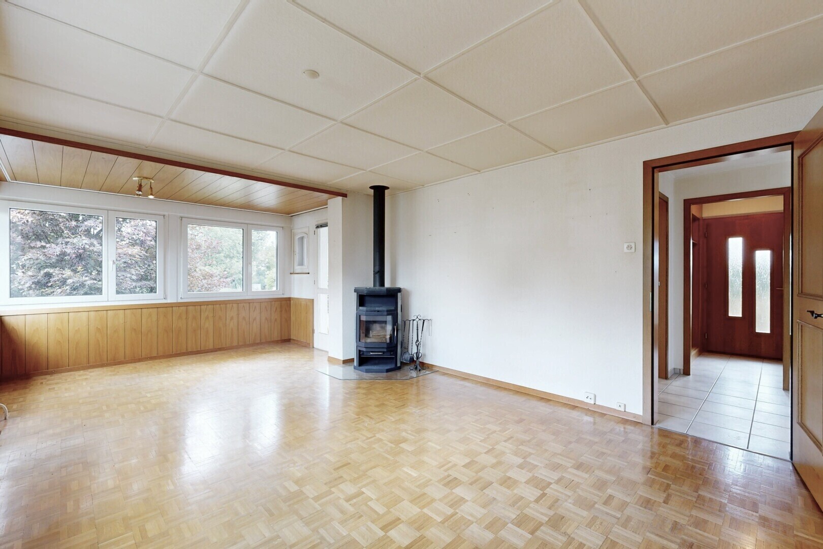 spare room featuring a wood stove and a paneled ceiling