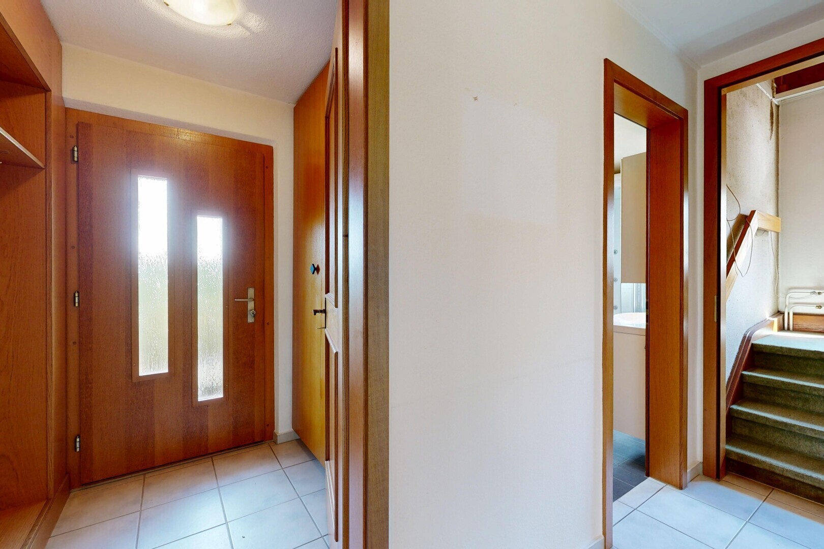 hall with light tile patterned floors