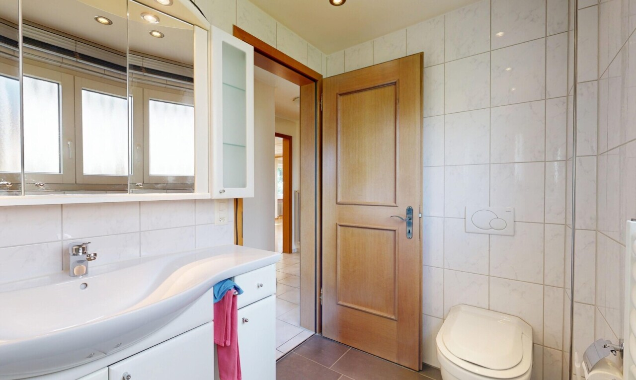 half bath with tile walls, vanity, dark tile patterned flooring, and recessed lighting