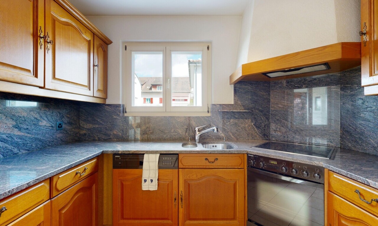 kitchen featuring custom range hood, black appliances, backsplash, and brown cabinets