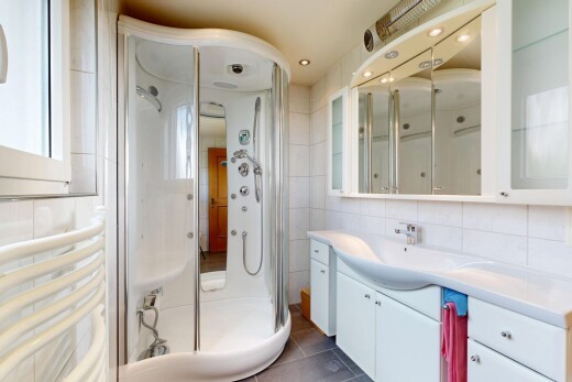 bathroom with a stall shower, vanity, tile walls, dark tile patterned flooring, and tasteful backsplash