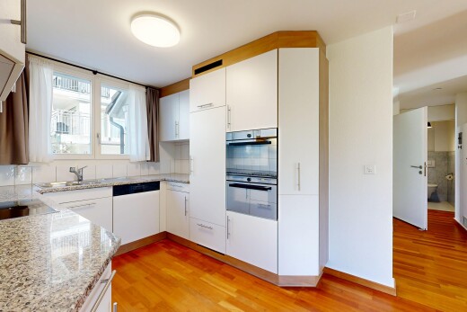 küche mit weiße schränke, inside property, wood finish floor, holzfußboden, und natural light