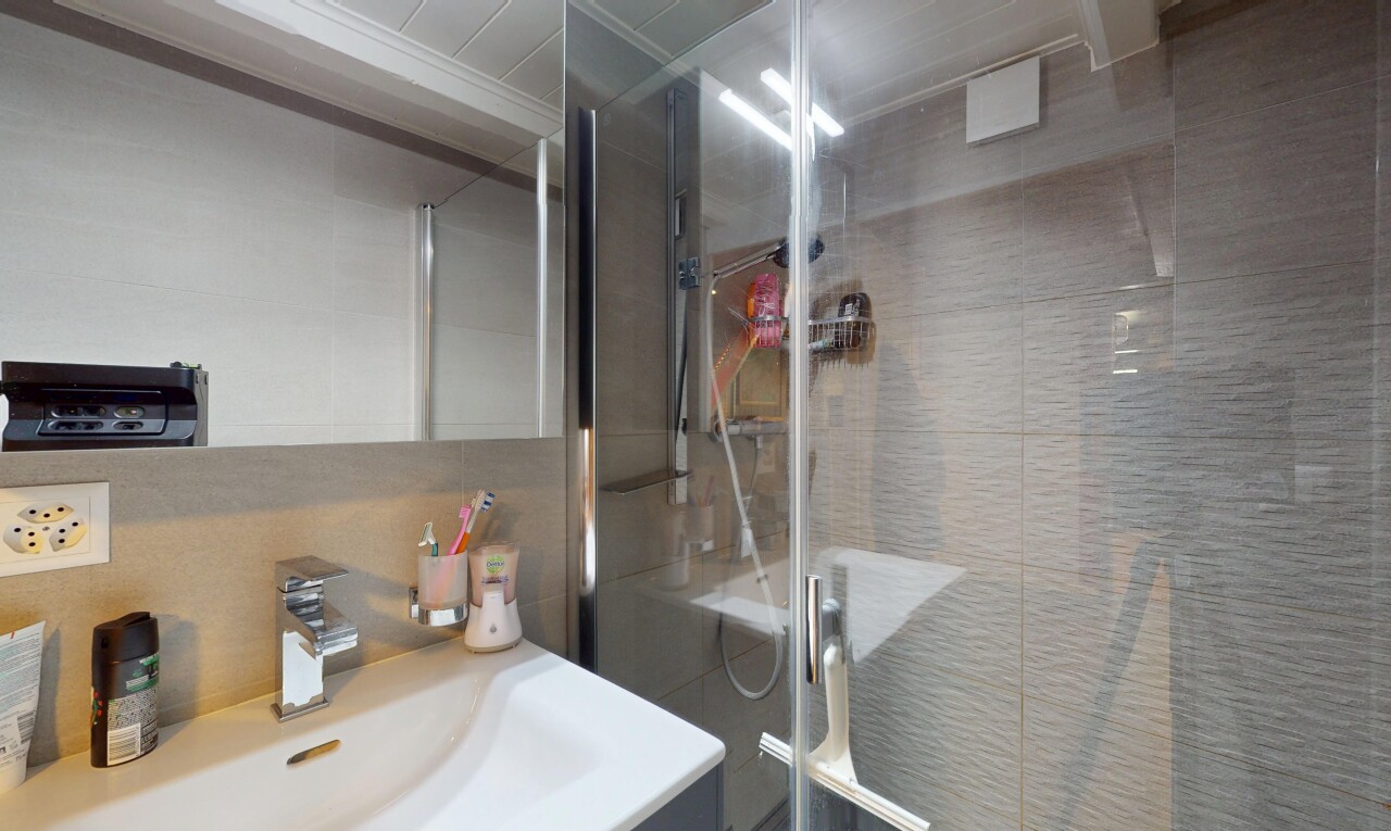 full bath featuring vanity, a stall shower, and crown molding
