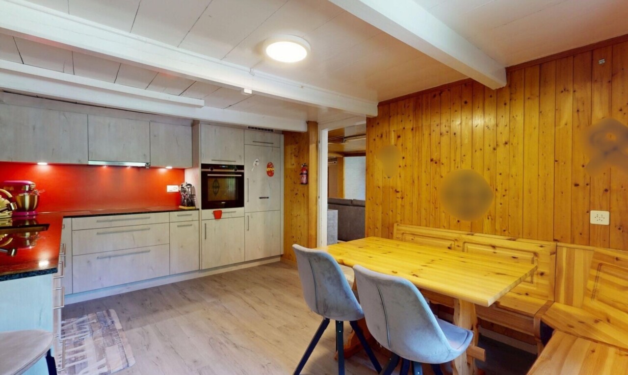 kitchen with beamed ceiling, wooden walls, oven, light wood-style floors, and dark countertops