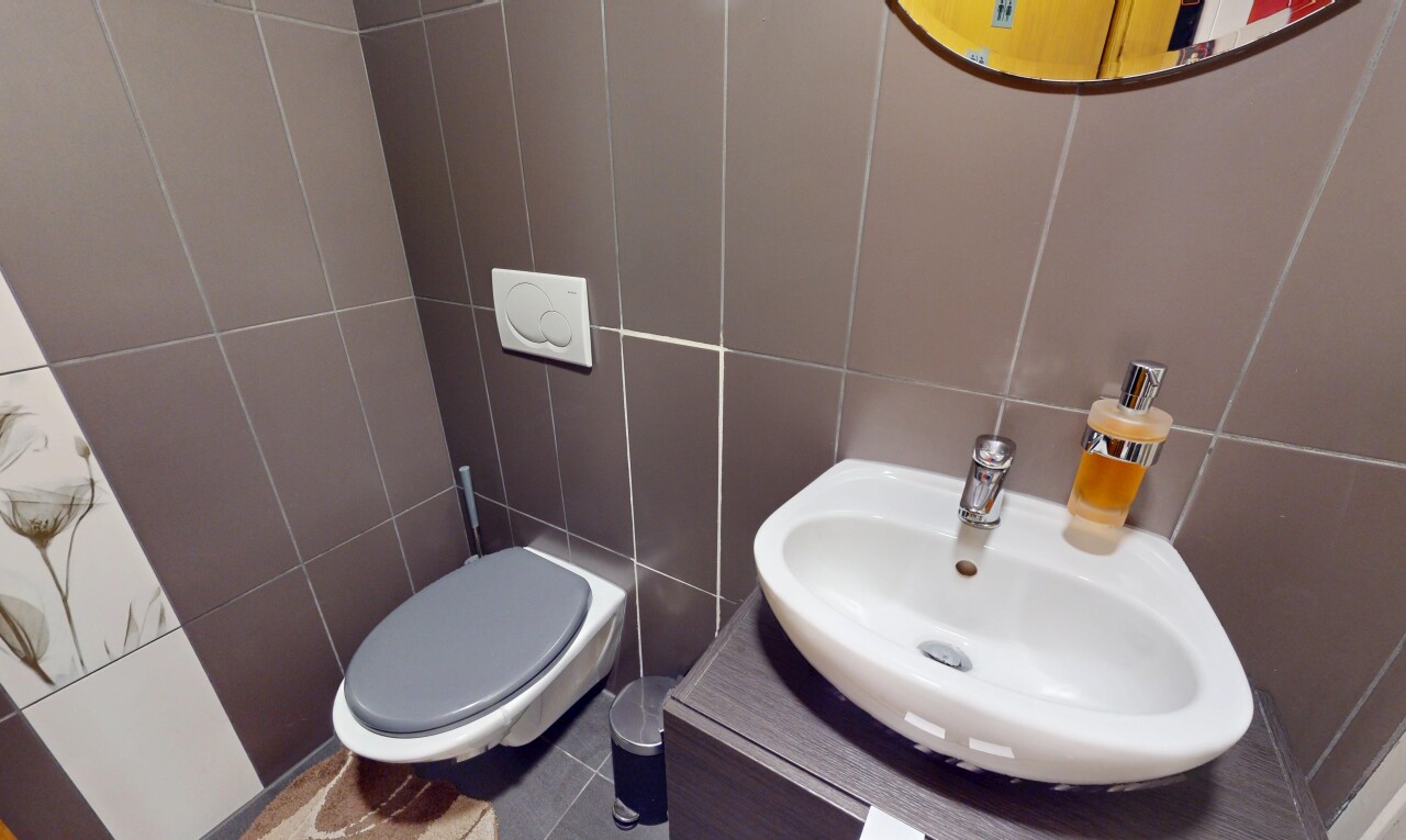 half bath featuring tile walls and vanity