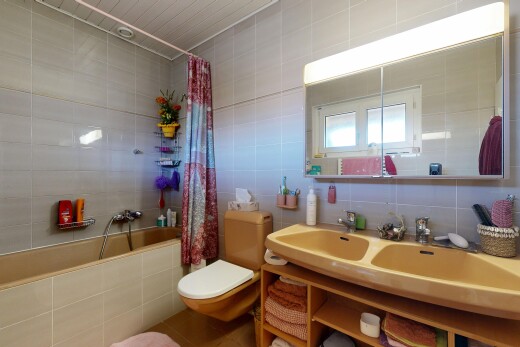 bathroom featuring tile walls, tiled shower / bath combo, backsplash, and double vanity