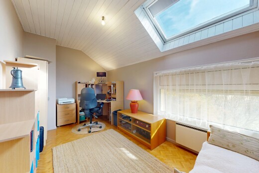 living area featuring plenty of natural light, a desk, radiator heating unit, a skylight, and a vaulted wood ceiling