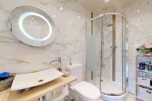 bathroom with a marble finish shower and tile walls