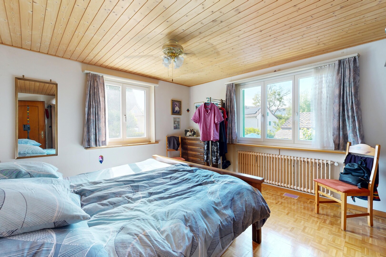 zimmer / schlafzimmer mit kühler, drywall, gipskartonwand, natürliches licht, und wood ceiling