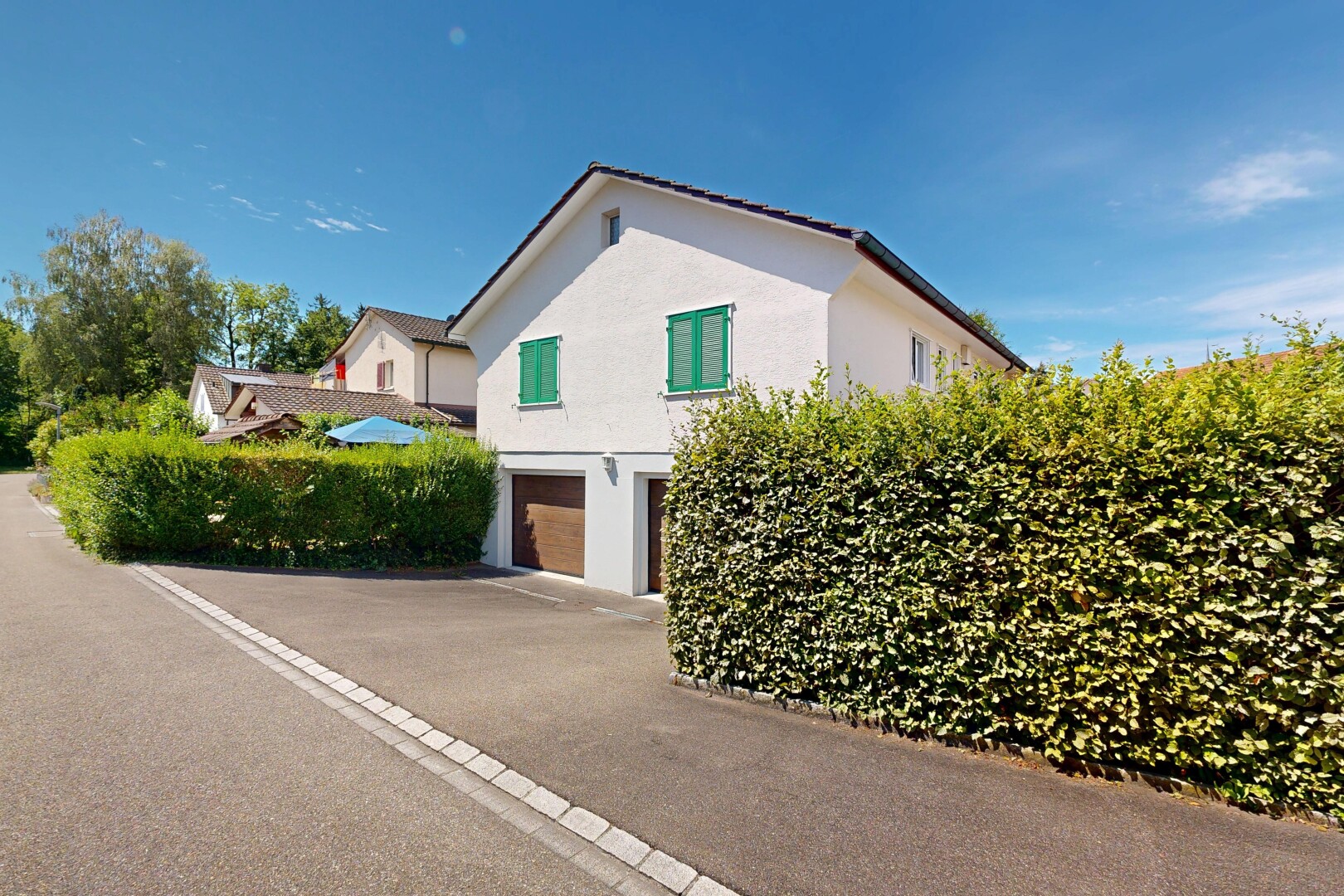 außenansicht mit eingebaute garage, stuckverkleidung, day time, property visible, und auffahrt