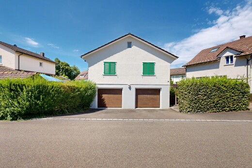außenansicht mit eingebaute garage, property visible, day time, stuckverkleidung, und auffahrt