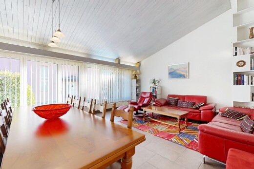 living room featuring healthy amount of natural light, vaulted ceiling, and tile patterned floors